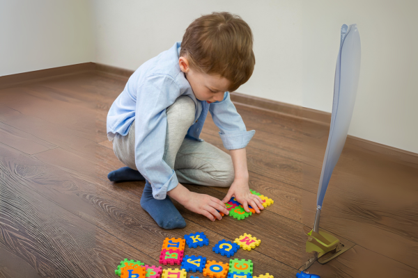 Niño jugando con piezas de alfabeto que representan la formación de programas inconscientes en la infancia